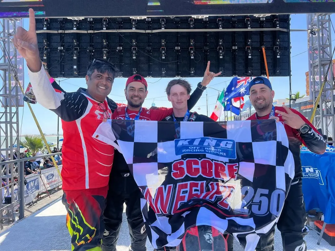 The reward for all the hard work. Our team celebrating a podium finish at the San Felipe 250, holding the checkered flag high. This is what happens when passion and preparation meet.
