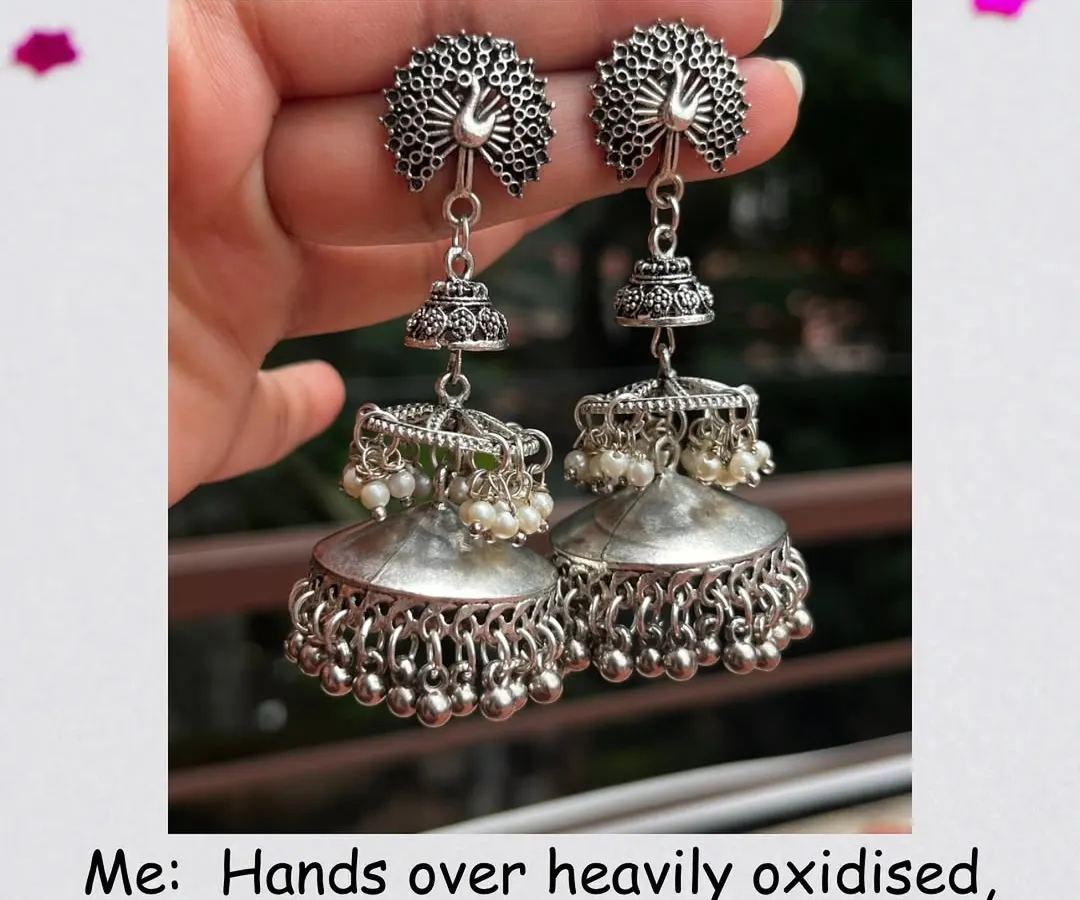 In my world, a bold, heavily oxidised statement jhumka is the perfect touch of minimalism. This pair, with its intricate peacock design and layered domes, is for those who love their jewellery to tell a story.