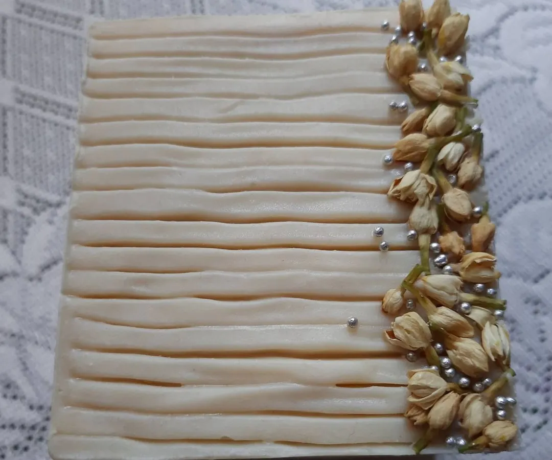This is my Cooling Ice Apple soap, one of the most elegant bars I've ever made. The design is inspired by nature, with delicate ridges and real dried jasmine buds, making it a beautiful and functional piece of art for your bathroom.