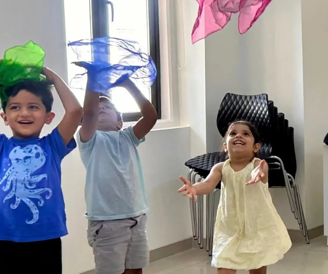 The pure, uninhibited joy of music and movement in our Discover Music class. We use colorful props like these scarves to help our youngest students feel the rhythm and express themselves, making learning an exciting and playful experience.