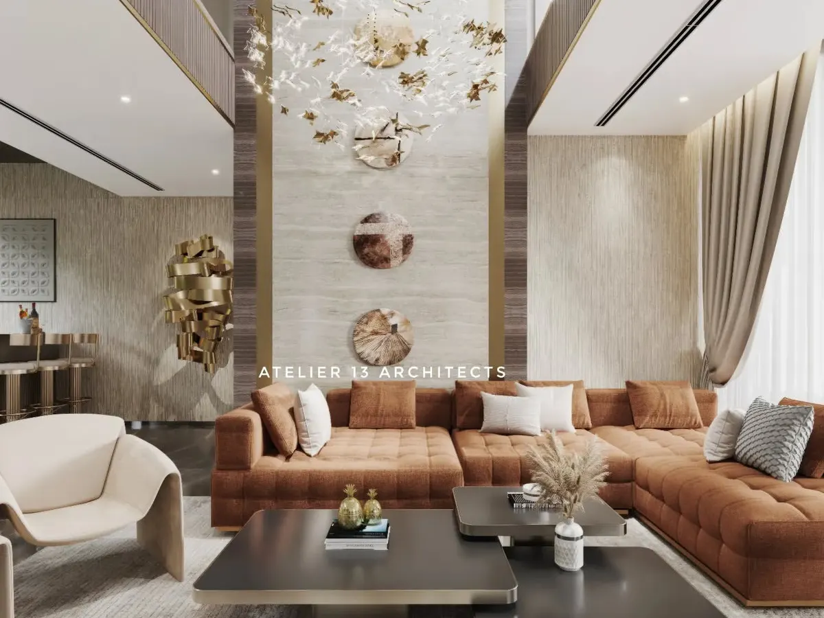 Inside one of our farmhouse projects, this double-height living space is designed for both grand entertaining and intimate family life. The room features a custom tan L-shaped sofa, elegant Italian chairs, and a striking wall clad in beige marble, all illuminated by a bespoke crystal chandelier.