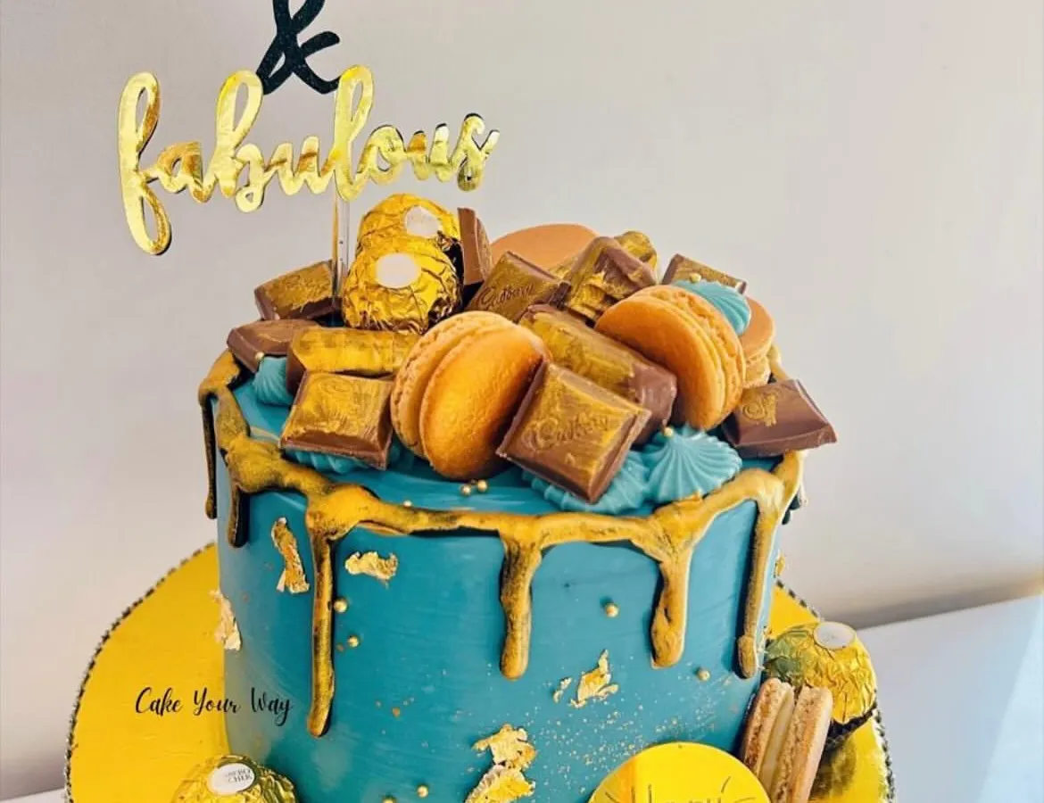 Turning 40 is a milestone that deserves a showstopper. I designed this '40 & Fabulous' cake with a rich teal buttercream, a dramatic gold drip, and topped it with Ferrero Rocher, macarons, and chocolate bars for pure indulgence.