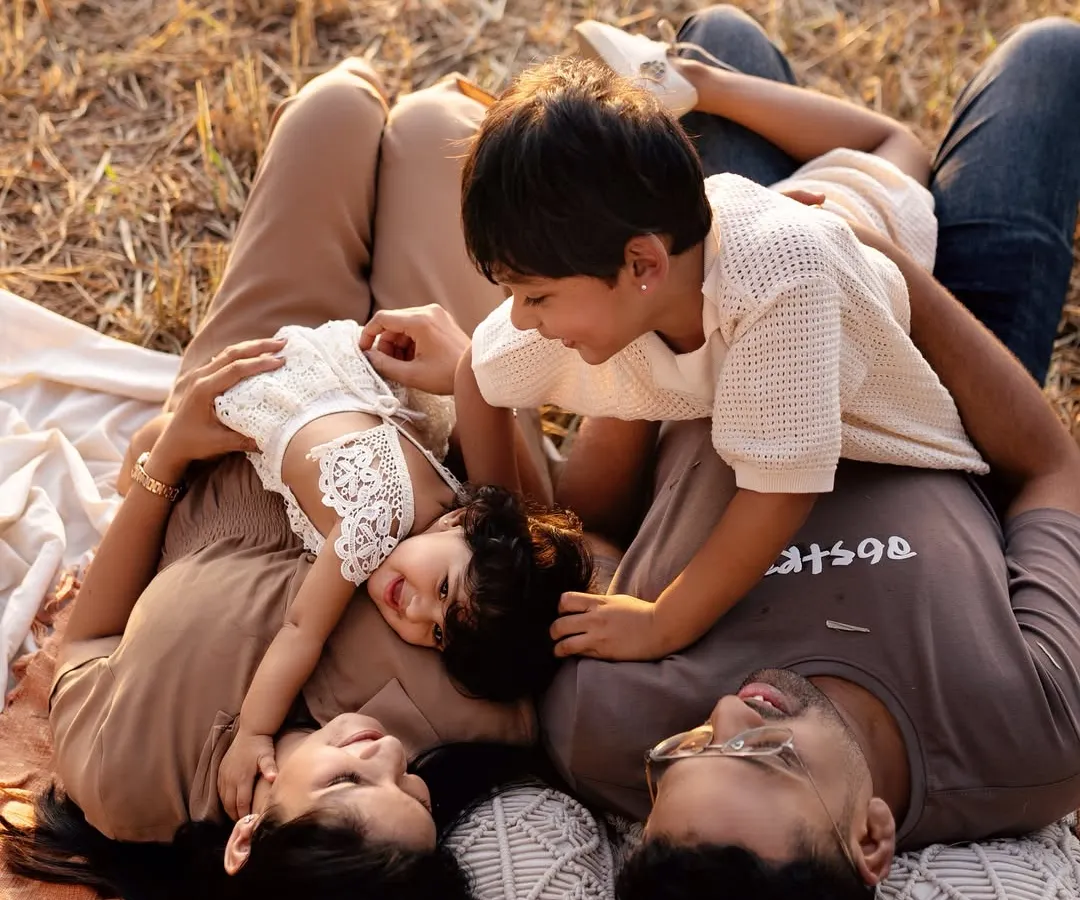 An outdoor family session isn't just about posing; it's about playing. This is a real family enjoying a beautiful day, with their two kids, captured in the warm evening light. These are the candid, joyful memories you'll look back on for years.
