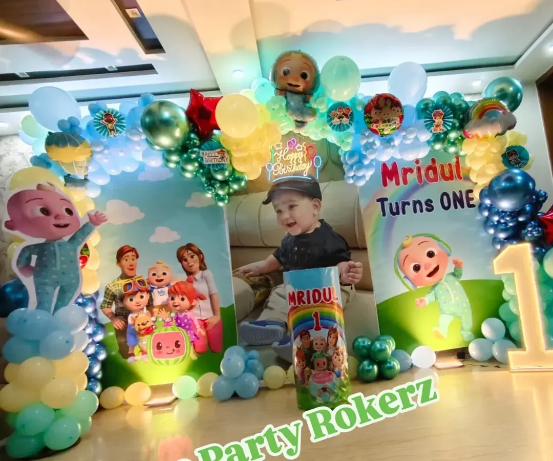 Here is a complete Cocomelon theme setup for a first birthday party at home. This package includes a custom printed backdrop with the child's photo, character cutouts, a full balloon arch, and a light-up marquee number.