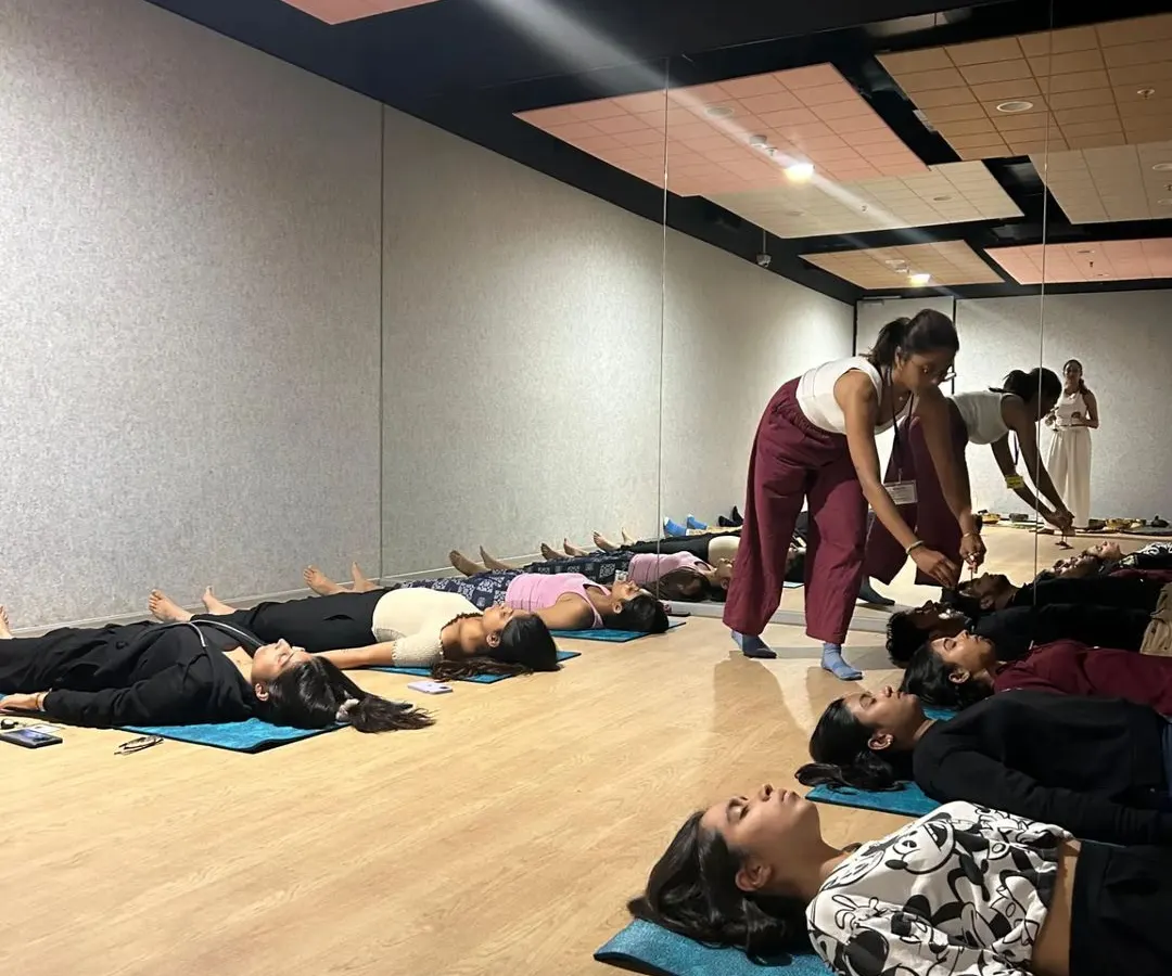 In my group classes, I focus on providing personal attention to help you find the right alignment and deepen your practice safely. Here, I'm assisting a student during a corporate wellness session to ensure they get the most out of their relaxation.