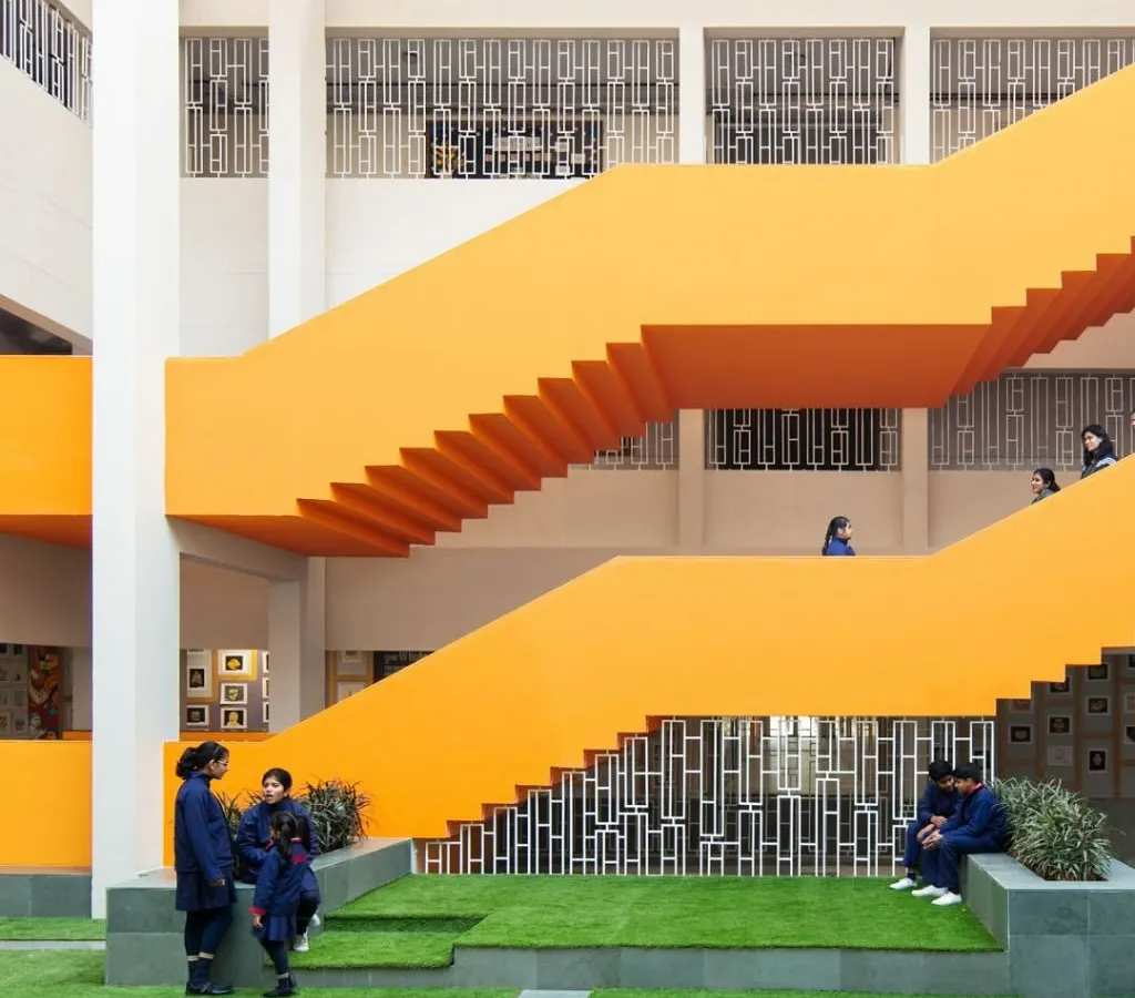 We transform overlooked "in-between" spaces into lively hubs for student interaction. This vibrant orange staircase and multi-level courtyard at SMR Jaipuria School is more than just a way to get from one floor to another; it's a place to pause, connect, and build community.