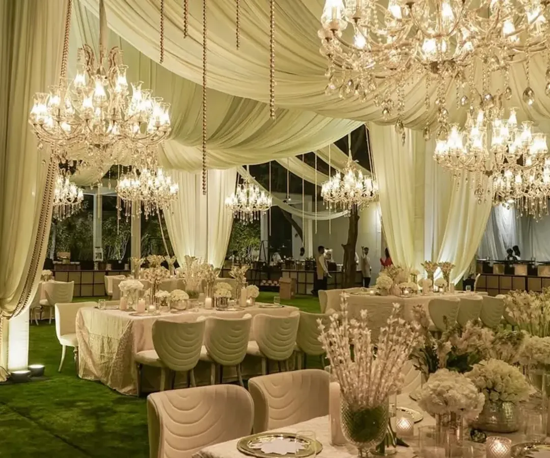 Beneath a flowing canopy of ivory fabric and a sky of glittering chandeliers, we set the stage for an evening of pure elegance. This all-white and gold theme creates a timeless and luxurious dining experience for guests.