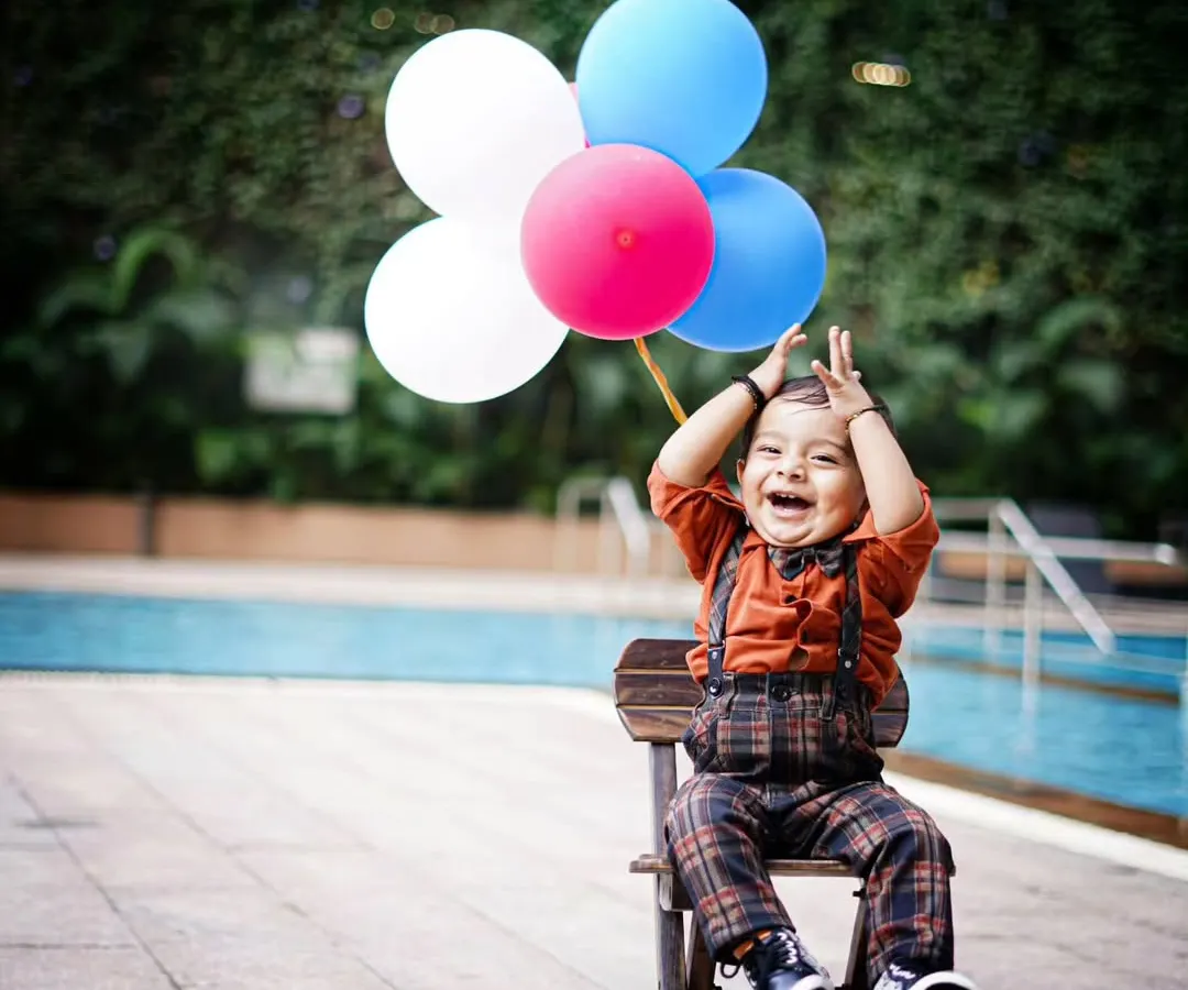 The purest joy is unscripted. This moment of laughter, with balloons ready for fun by the poolside, is exactly what I aim to capture. It's all about real smiles and happy kids.