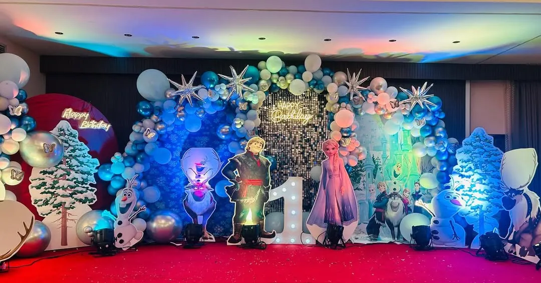 This Disney Frozen theme is perfect for creating a magical winter wonderland. I used a silver shimmer wall, hundreds of blue and white balloons, snowflake accents, and life-sized cutouts of Elsa, Anna, and Kristoff for this special first birthday party.