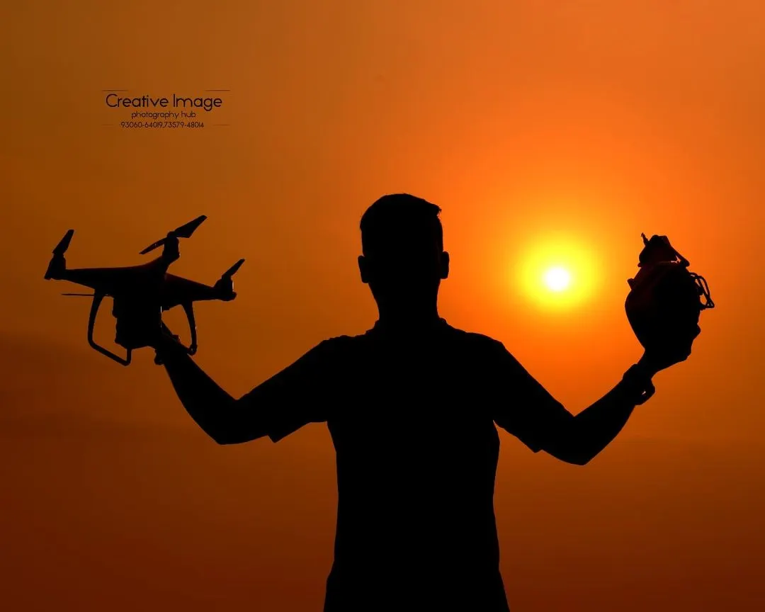 A creative silhouette I captured against a vibrant sunset, holding both my drone and my camera. This image represents my passion for both aerial and ground photography, blending artistry with technical skill.