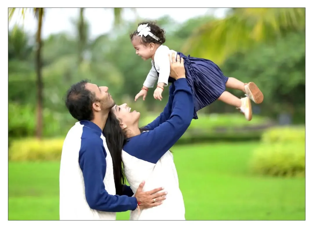 A candid moment of pure joy during an outdoor family photoshoot in a Mumbai park. We love capturing these dynamic, natural light portraits that show the playful side of your family's bond.