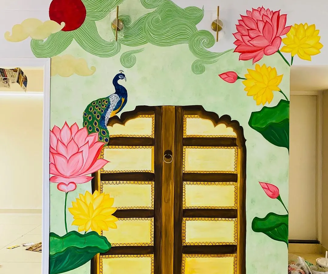 This traditional backdrop for a pooja mantap is one of our favorite projects. We worked closely with the client to bring together elements like the Jaipur-style door, vibrant Pichwai lotuses, and a proud peacock, creating a truly divine space.