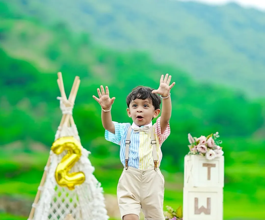Capturing the pure energy of a two-year-old. This outdoor session uses the beautiful green landscape as a natural backdrop, complemented by our boho-style props like a macrame teepee and "TWO" blocks to celebrate his second birthday milestone.