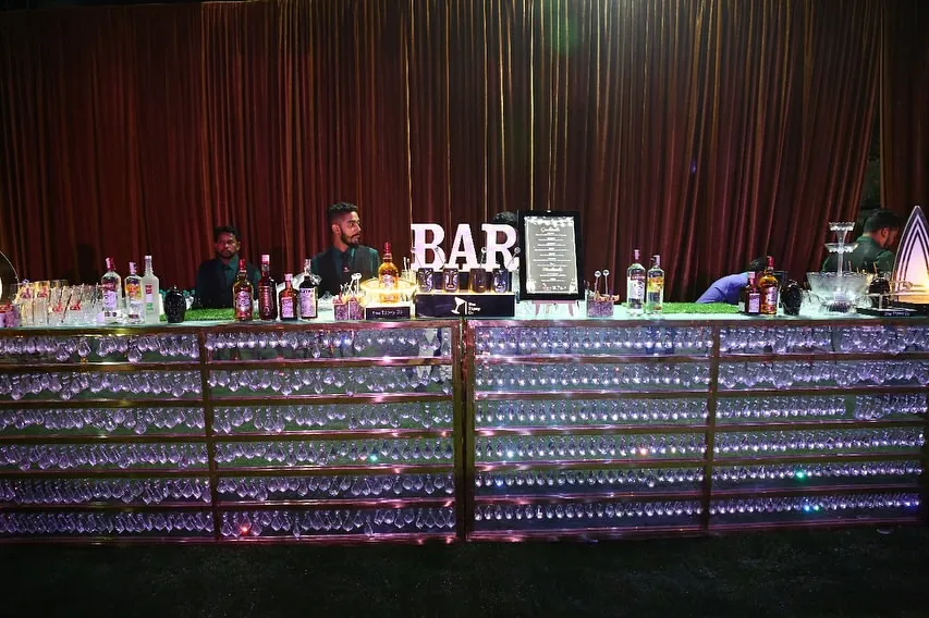 For grand celebrations, we deliver a bar to match. This setup features a fully stocked, LED-illuminated bar, ready to serve hundreds of guests with speed and style, making it a stunning centerpiece for any large wedding or corporate event.