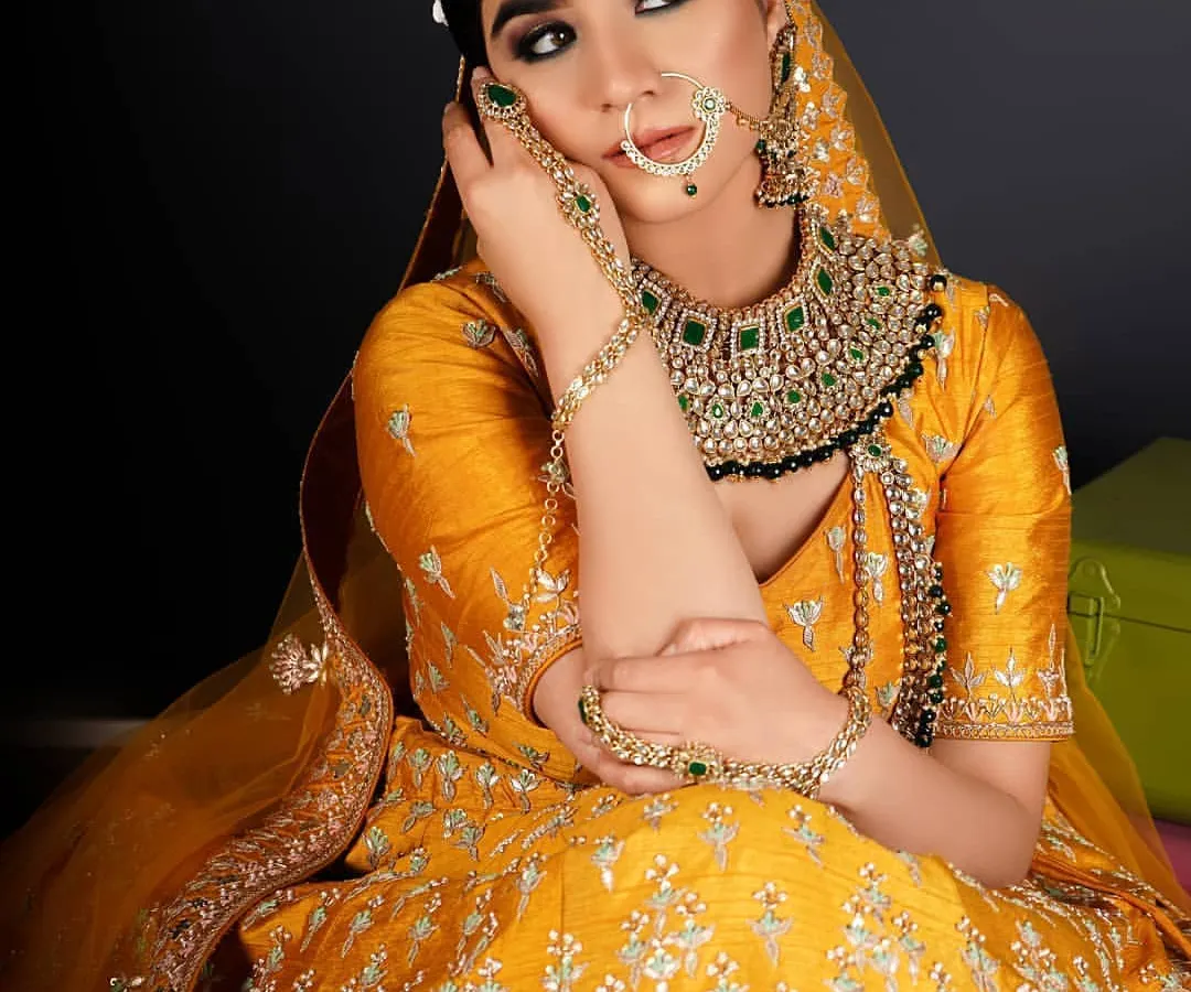 This is a perfect example of a vibrant Haldi or Mehendi bridal look. The focus was on flawless skin and defining the eyes to stand out against the beautiful yellow lehenga and heavy green Kundan jewelry.