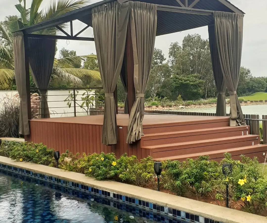 We designed this stunning poolside gazebo at Prestige Golfshire, Bangalore, for Mr. Anurag. It features a raised WPC deck and is surrounded by lush plants, creating a tranquil escape right by the water.
