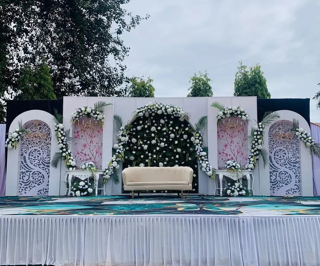 For this outdoor engagement, I designed a clean and elegant stage. The backdrop features intricate white panels and a stunning arch of fresh white flowers, creating a perfect focal point for the ceremony.