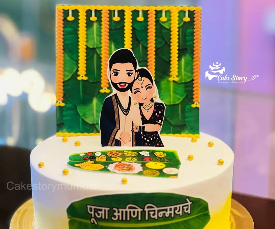I love creating cakes that celebrate our beautiful Maharashtrian traditions. This one was for a 'Kelvan' ceremony, a special pre-wedding ritual. It features custom caricatures of the couple and traditional motifs like banana leaves and marigold flowers.