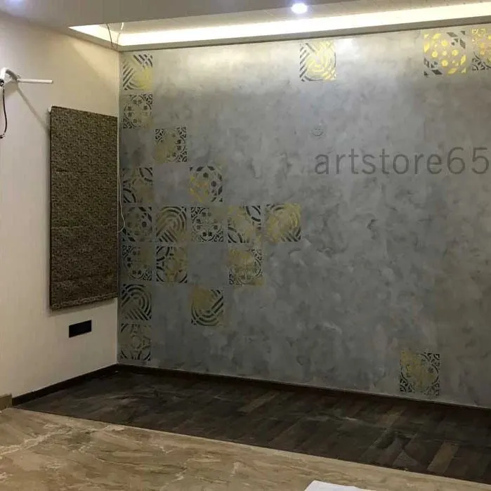 We created this elegant bedroom accent wall using a soft, cloudy grey base texture. The look is elevated with geometric and floral patterns stenciled in a shimmering metallic gold paint, adding a touch of luxury and warmth.