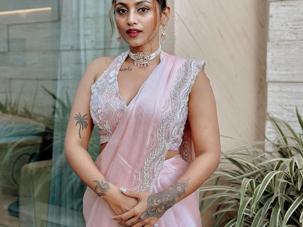 For me, Indian festive fashion is about blending tradition with a modern feel. This look features a delicate pink saree with an embellished halter-neck blouse, creating a style that's both elegant and contemporary.