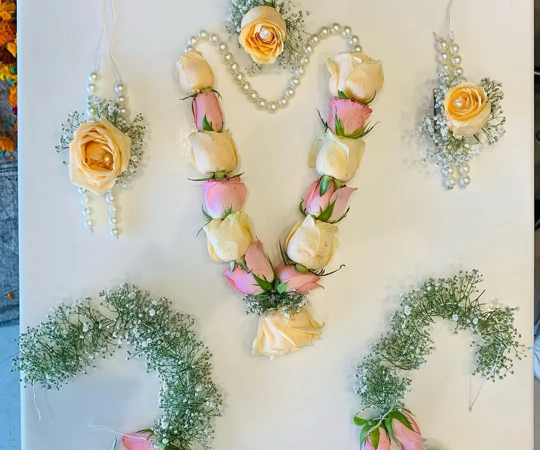 This is one of my complete fresh flower jewelry sets, perfect for a bride's haldi or mehndi ceremony. It features a floral haar made with delicate pink and peach rose buds, matching hathphool for both hands, elegant karn phool earrings, and a maang tikka. I have woven in sprigs of baby's breath and delicate pearl strings to create a look that is both traditional and soft. Each piece is handcrafted to feel lightweight and comfortable throughout your event.