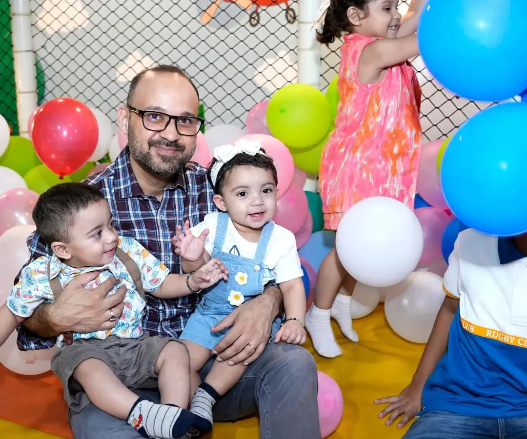 Look at these happy faces. A dad enjoys quality time with his little ones in our colorful ball pit, surrounded by balloons. It's all about creating these joyful family moments in a safe and fun environment.