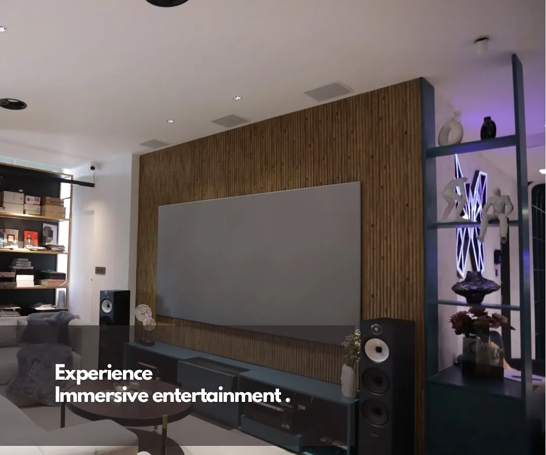 We believe world-class entertainment should blend perfectly with your home's design. This living room setup features a large format screen and high-fidelity tower speakers, creating a powerful media experience that complements the modern interior.