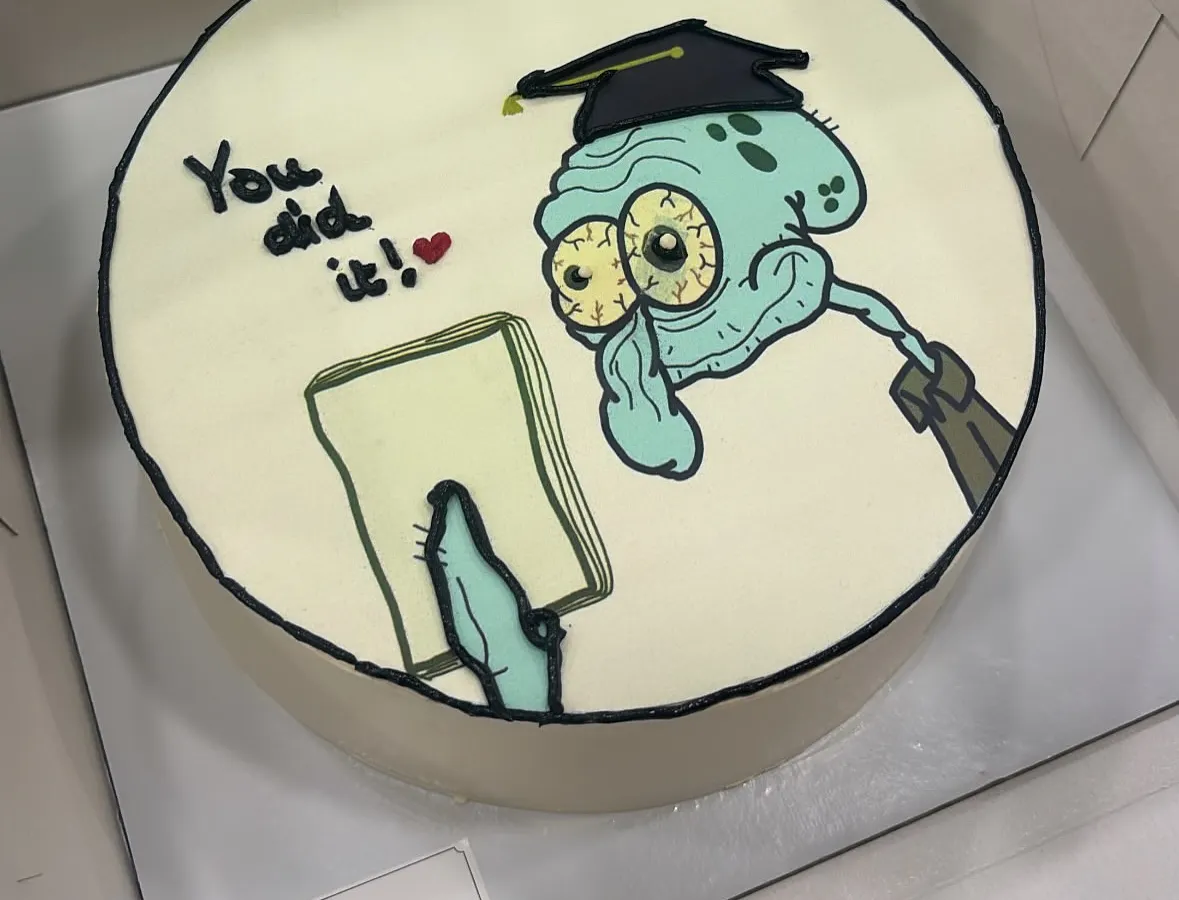 Celebrate with a smile. We love bringing your favorite characters and inside jokes to life with our hand-drawn doodle cakes, like this fun Squidward design for a graduation. It's all done in buttercream for maximum flavor.