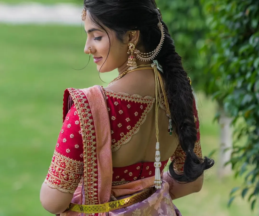 A statement back can transform an entire outfit. For this bride, I created a custom red raw silk blouse with intricate zari and zardosi embroidery, featuring a unique back design that perfectly complements her lavender Kanchivaram saree.