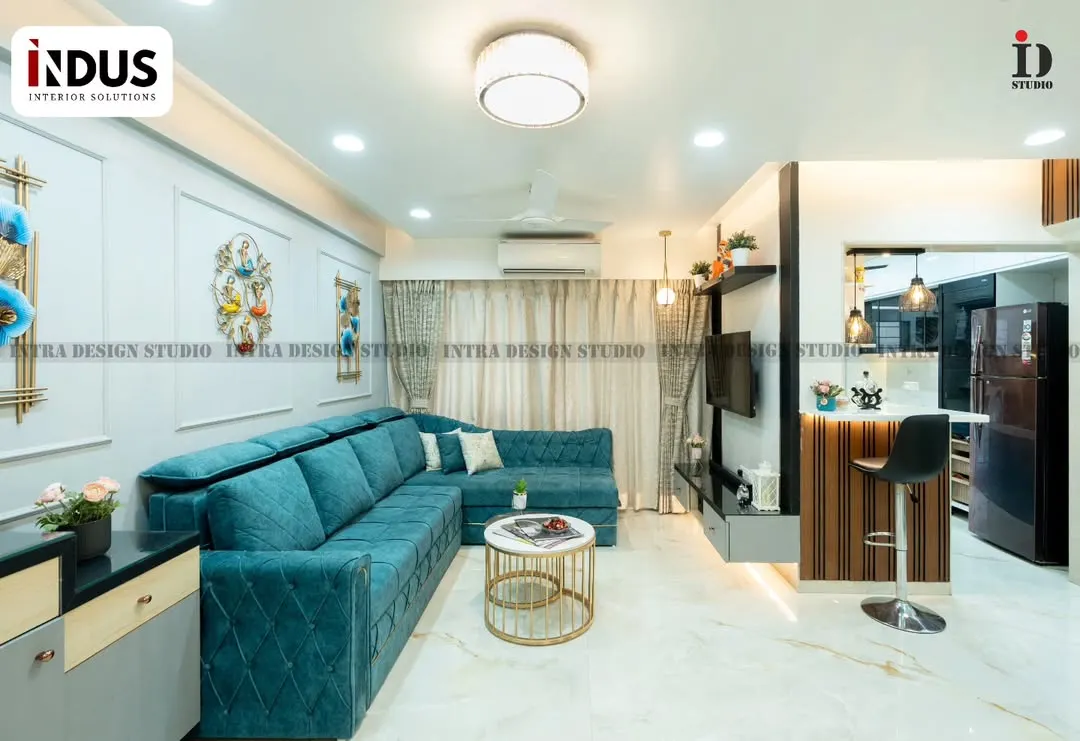 A look at a complete living room we designed, blending comfort and modern style. The vibrant teal L-shaped sofa, custom TV unit, and open-concept layout leading to the breakfast bar create a welcoming and cohesive family space.