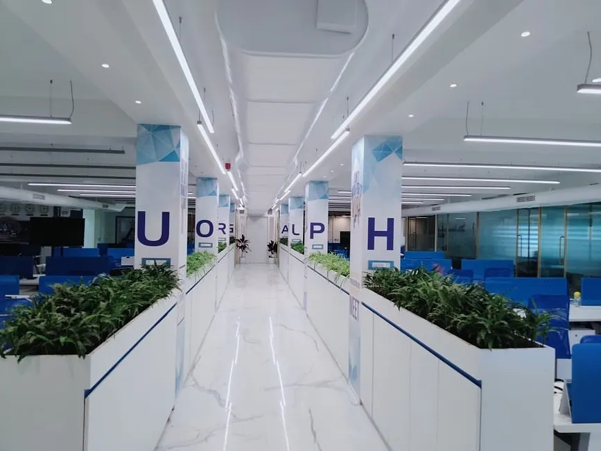 In this large open-plan office, we used custom-built planters to create natural, green dividers between workspaces. This biophilic design approach helps to define zones, reduce noise, and improve air quality without building solid walls, fostering a more collaborative and healthier work environment.