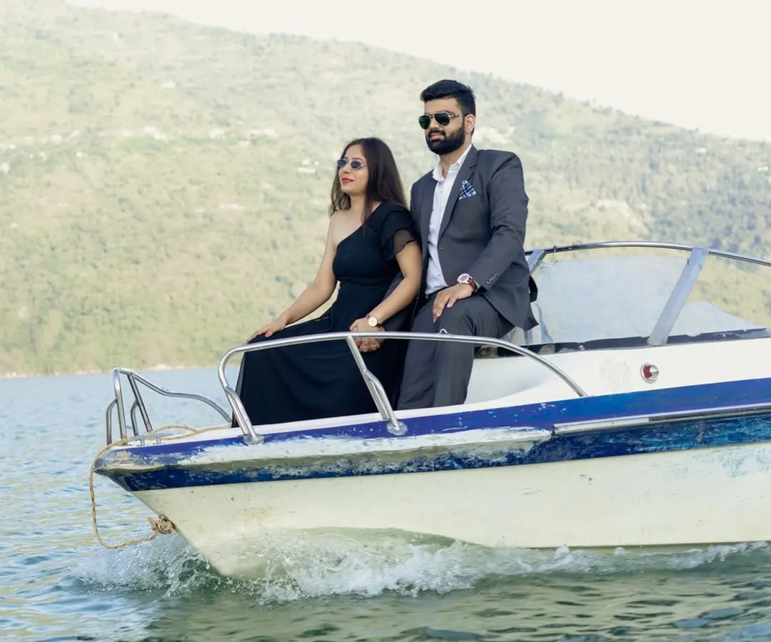 An adventurous couple enjoying a speedboat ride on Tehri Lake. This shot captures the thrill and joy of starting a new life journey together, set against a stunning natural backdrop.