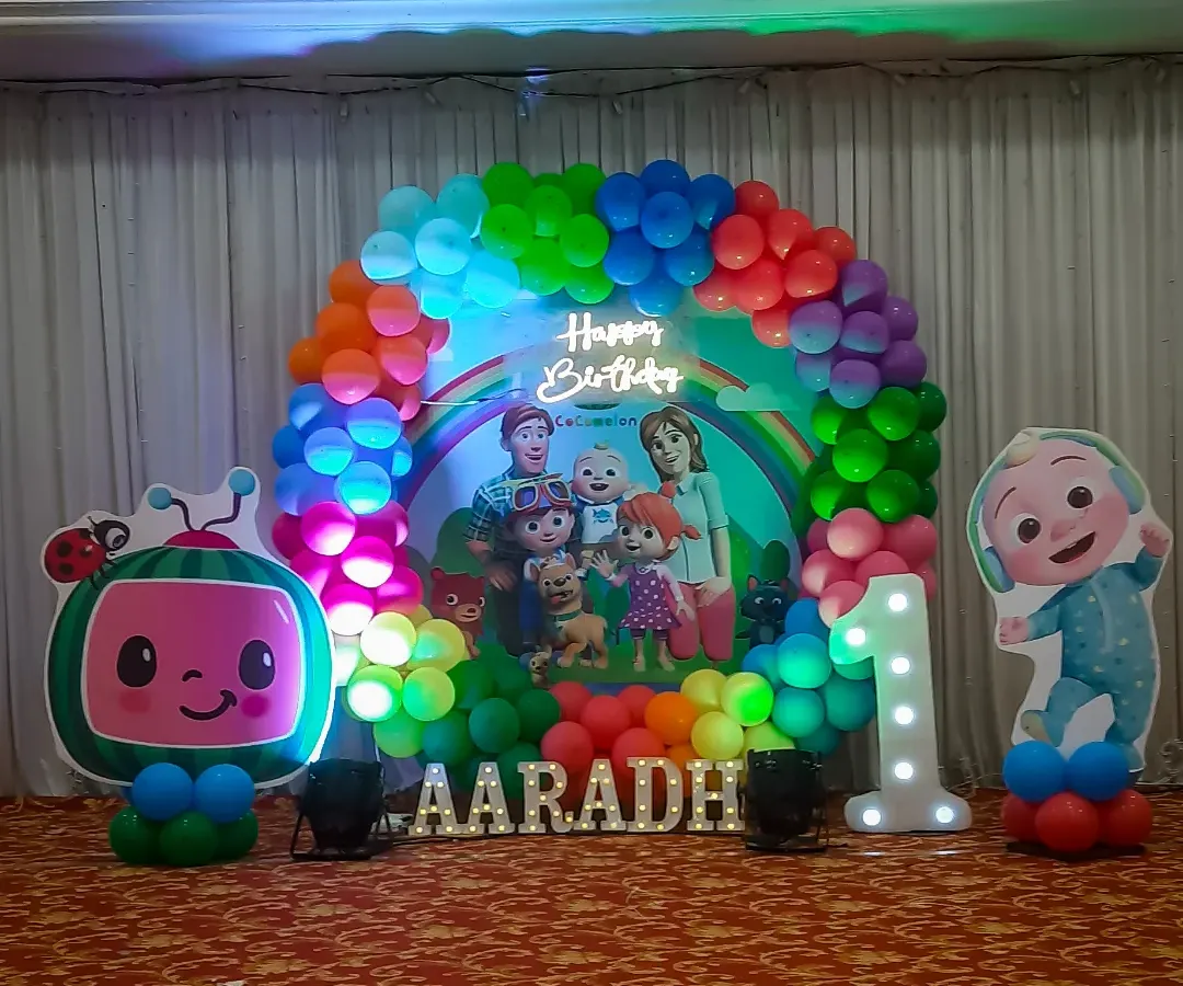For a child's first birthday, I created this vibrant Cocomelon themed stage decoration. It features a colorful balloon arch, a personalized backdrop with the birthday boy's name, character cutouts, and a light-up number '1' to make the celebration extra special.