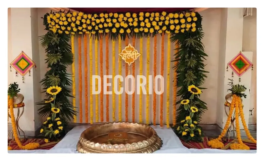For this Haldi ceremony, I created a classic backdrop using strings of fresh marigolds. The setup is framed with lush greenery and sunflowers, creating a bright and auspicious atmosphere for the pre-wedding ritual.