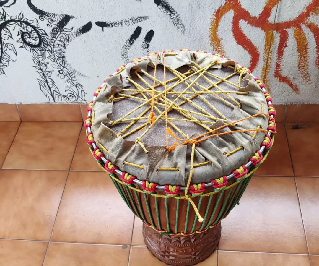 Here you can see the 'dry pull' in progress, which is the toughest part of making a djembe. This traditional West African technique involves weaving and pulling ropes to create the first major tension on the goatskin, setting the foundation for the drum's powerful sound.