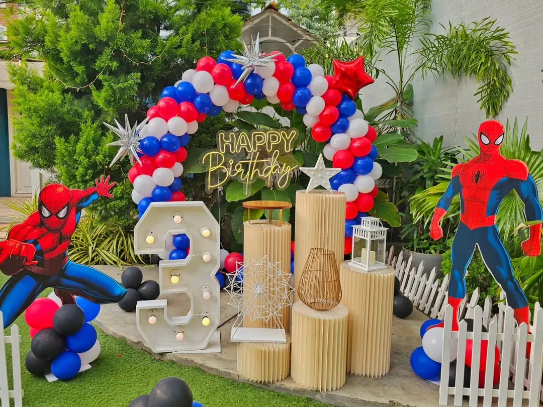 I bring popular kids' themes to life, like this action-packed Spider-Man party. The setup includes a custom balloon arch, large character cutouts, and a light-up marquee number, creating an exciting world for the birthday boy.