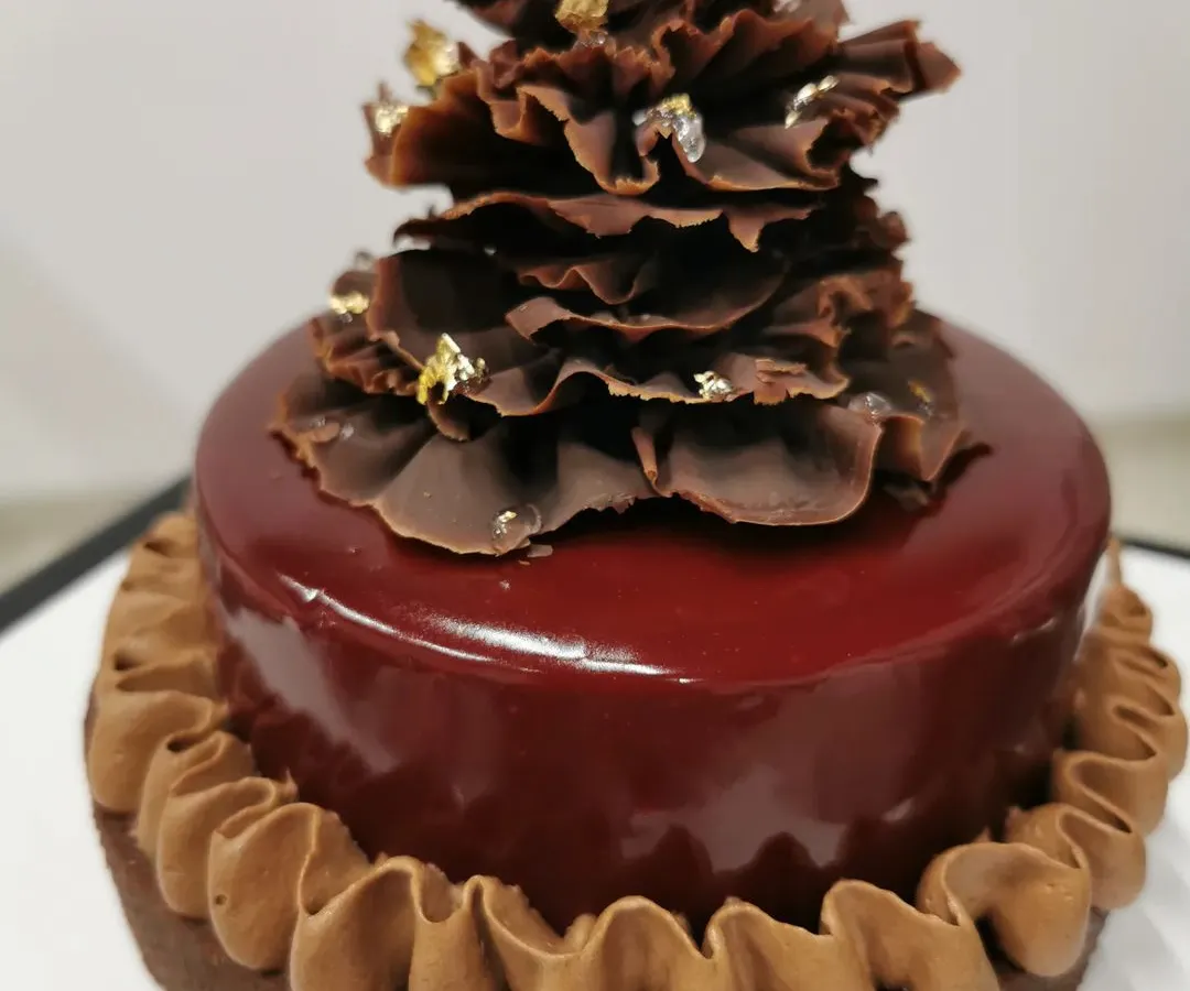 This is my raspberry chocolate tart. It has a rich, buttery chocolate crust, a smooth chocolate filling, and a glossy raspberry glaze, all topped with delicate chocolate ruffles and a touch of gold leaf. It’s a dessert for true chocolate lovers.