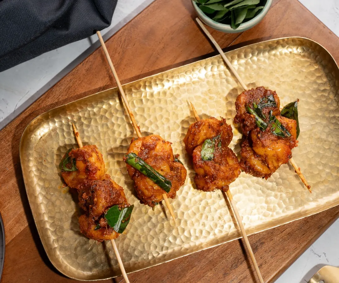 We present our Ghee Roast Prawns on satay sticks. Each prawn is slow cooked in a handcrafted ghee roast masala, offering a modern, elegant way to enjoy this traditional coastal flavor at your cocktail party or sundowner.