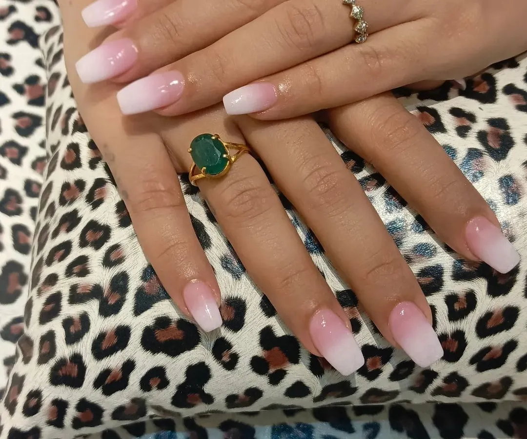 This is a perfect example of our classic pink-to-white ombre nail extensions. We achieve a seamless gradient on a squared coffin shape, creating a sophisticated and clean look that is perfect for any occasion, from daily wear to special events.