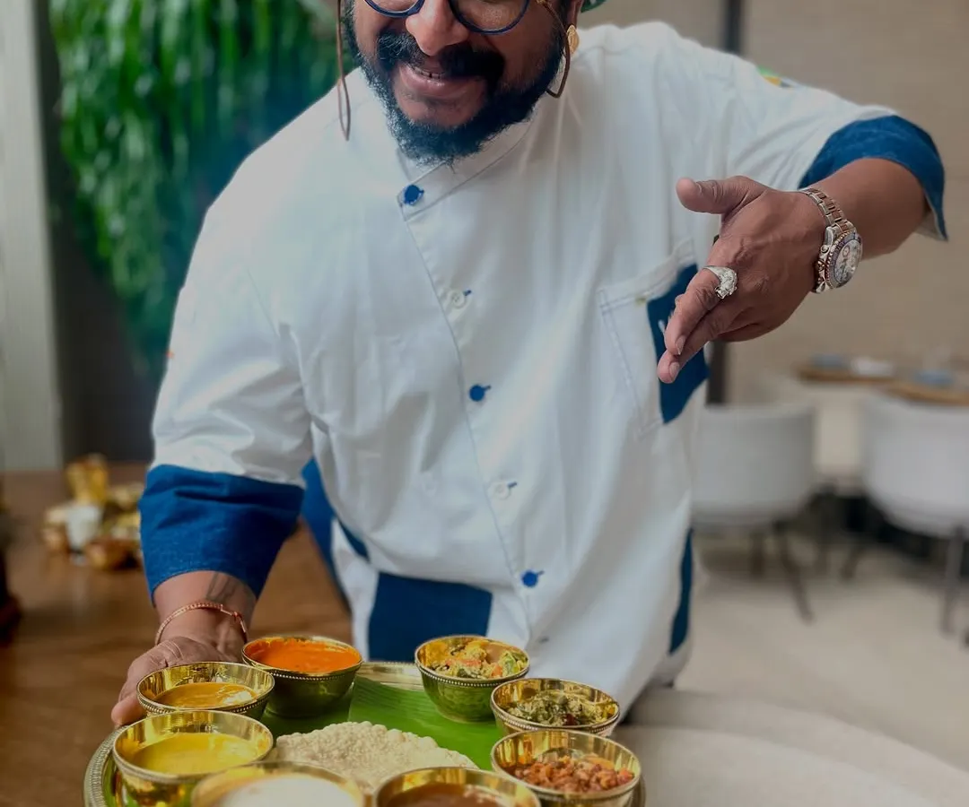 This is the heart of our celebration, a Sadya served on a traditional banana leaf. I am holding a platter filled with small bowls of curries, thoran, and pickles, each one a taste of Kerala's rich agrarian heritage and festive spirit. It's a wholesome experience I am proud to share.
