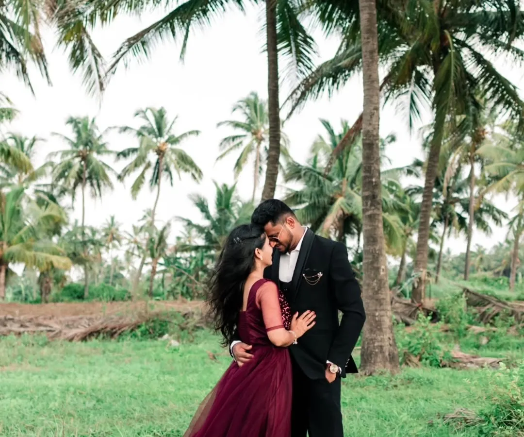 An intimate embrace amidst the serene greenery and towering palms of a destination shoot. We specialize in finding beautiful natural backdrops that complement a couple's story.
