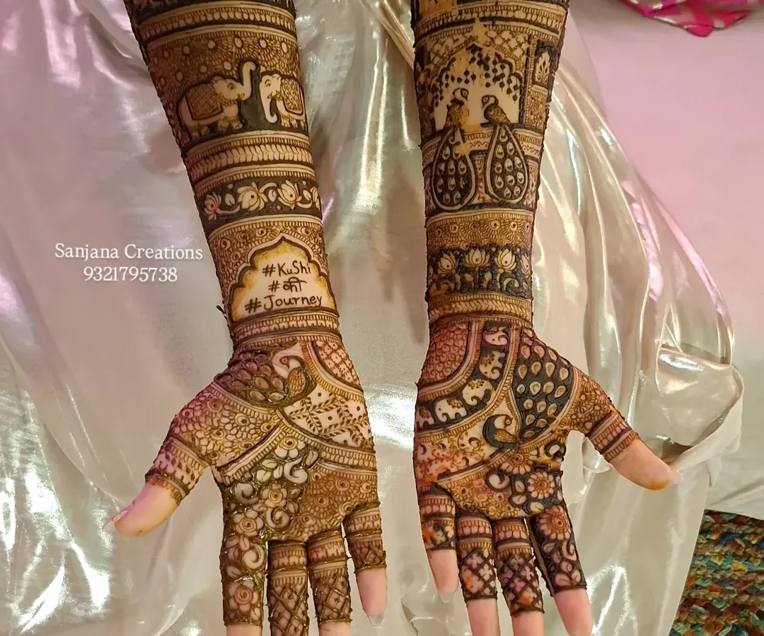A full bridal mehndi design fit for a queen. This intricate artwork features traditional motifs like elephants and palace architecture, covering the arms from fingers to elbow for a truly royal wedding look.