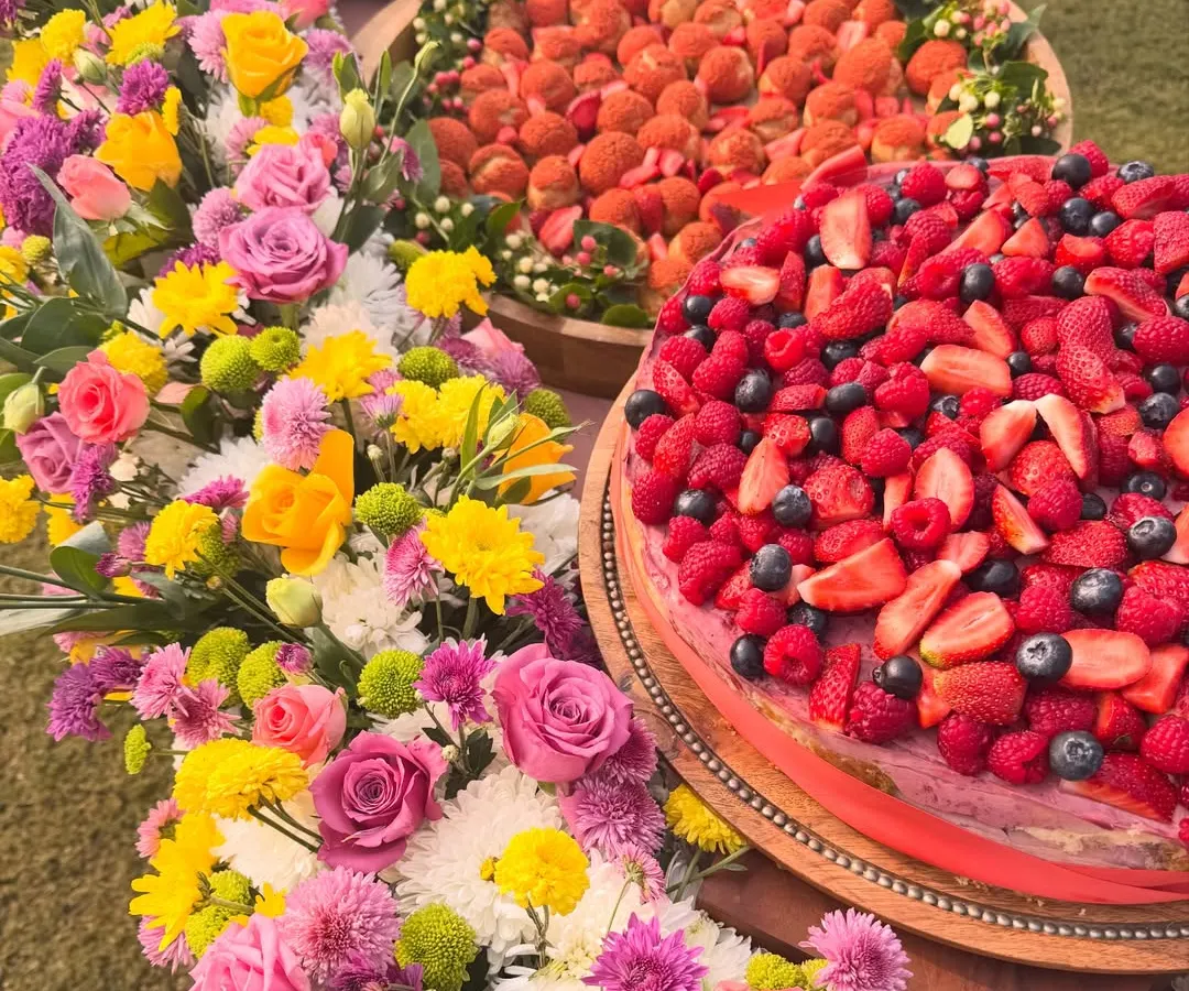 A beautiful dessert table I created for a special celebration, surrounded by fresh flowers. I love making your events beautiful and delicious with treats like my berry-topped cakes and fresh strawberry choux pastries.