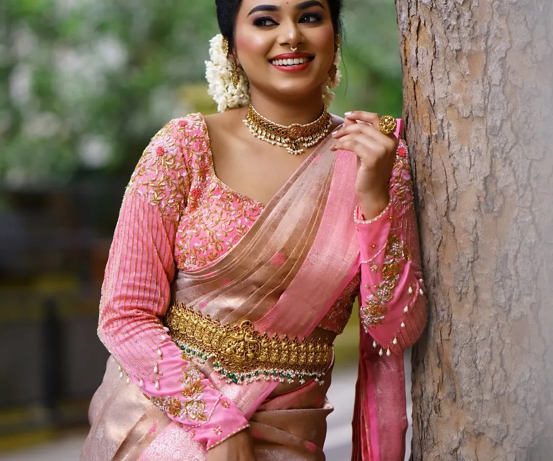 A happy client in a beautiful pink and gold silk saree for an outdoor event. My goal is always a flawless drape that lets you feel confident and at ease, no matter the occasion.