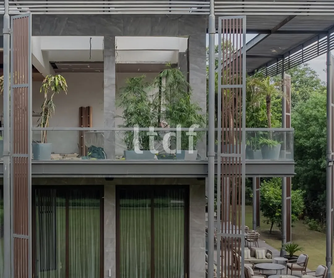 We designed this modern home to breathe with its natural surroundings. The structure uses raw concrete, warm wood, and expansive glass to dissolve the boundaries between the interior and the lush greenery outside, creating a seamless indoor-outdoor living experience.