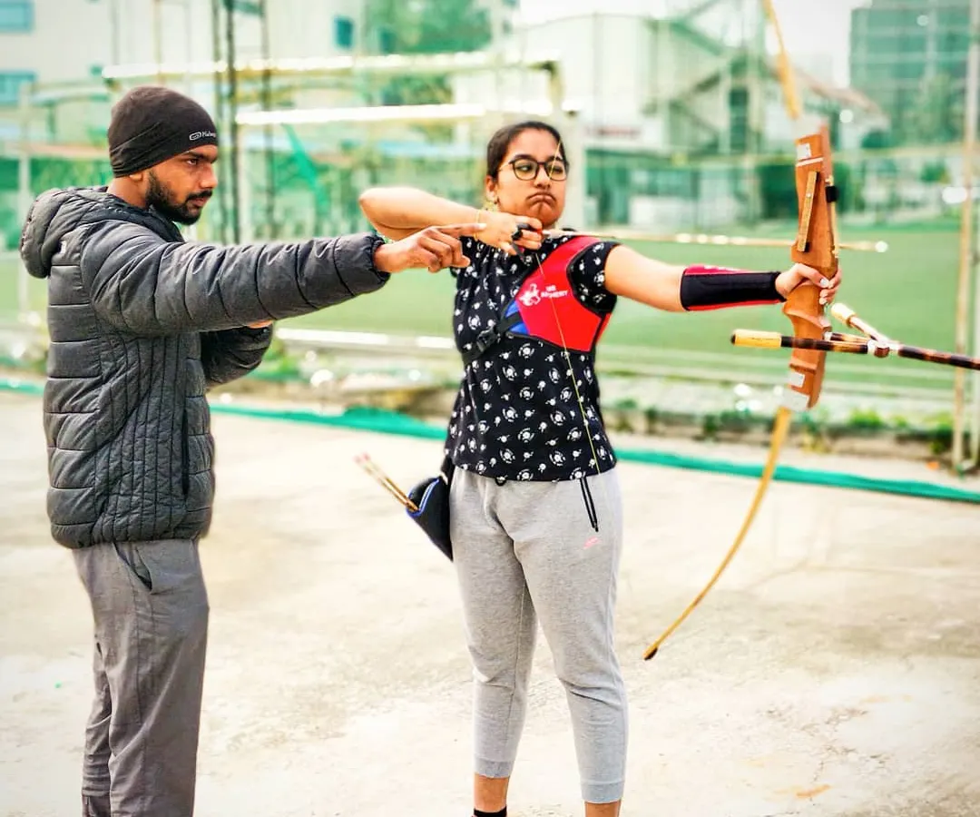 We believe in a hands-on approach. Here I am providing one-on-one archery form correction to a student, adjusting her elbow alignment to ensure a powerful and consistent shot. This personal attention is key to our training method.