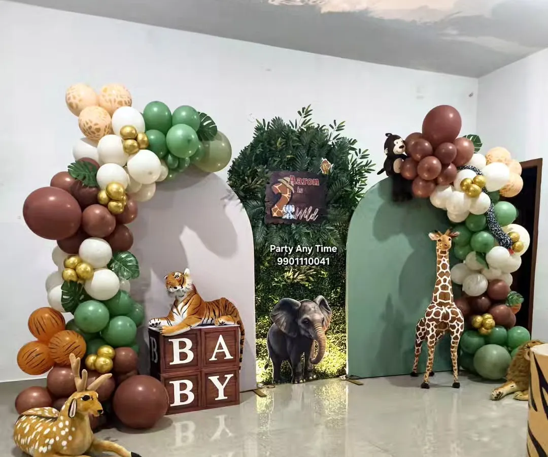 I create immersive jungle theme parties with life-sized animal props like tigers, deer, and giraffes. This setup features custom green and brown balloon arches, a grass wall backdrop, and themed "BABY" blocks, perfect for a wild first birthday or a baby shower.