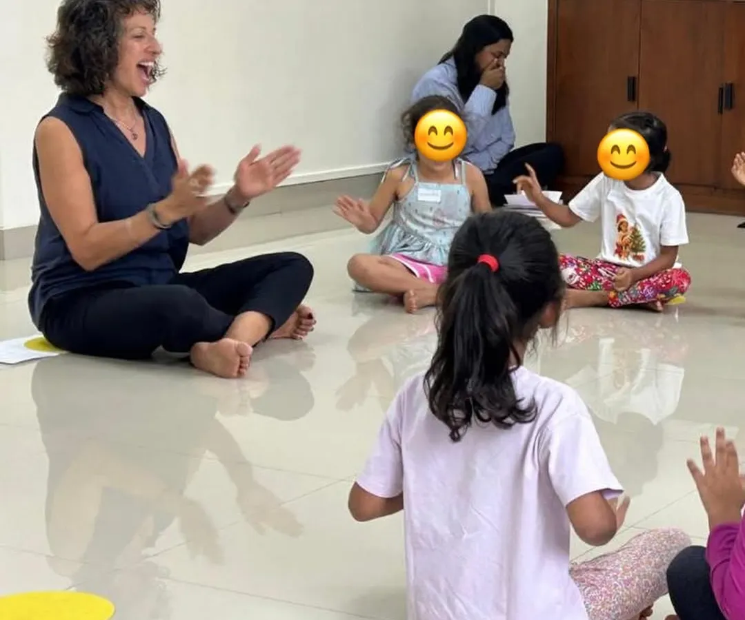 Our training is led by UK-based expert Naheed Shimala. This image captures a moment of joyful interaction in one of her sessions, demonstrating how she connects with young learners through expressive singing and hand gestures to teach musical concepts.