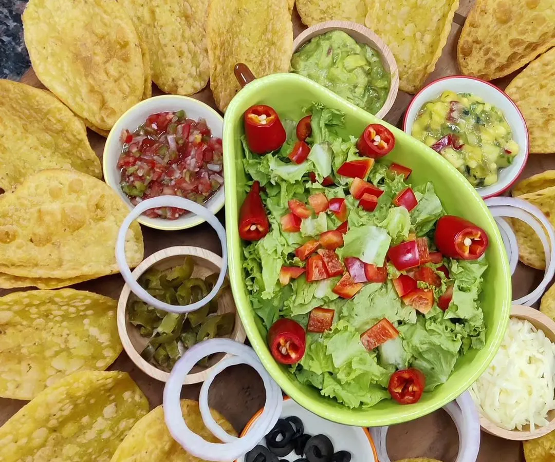 Get the party started with our vibrant Taco Platter. It comes with everything you need: crispy taco shells, fresh lettuce, salsa, guacamole, mango salsa, refried beans, and assorted toppings for a build-your-own taco experience.