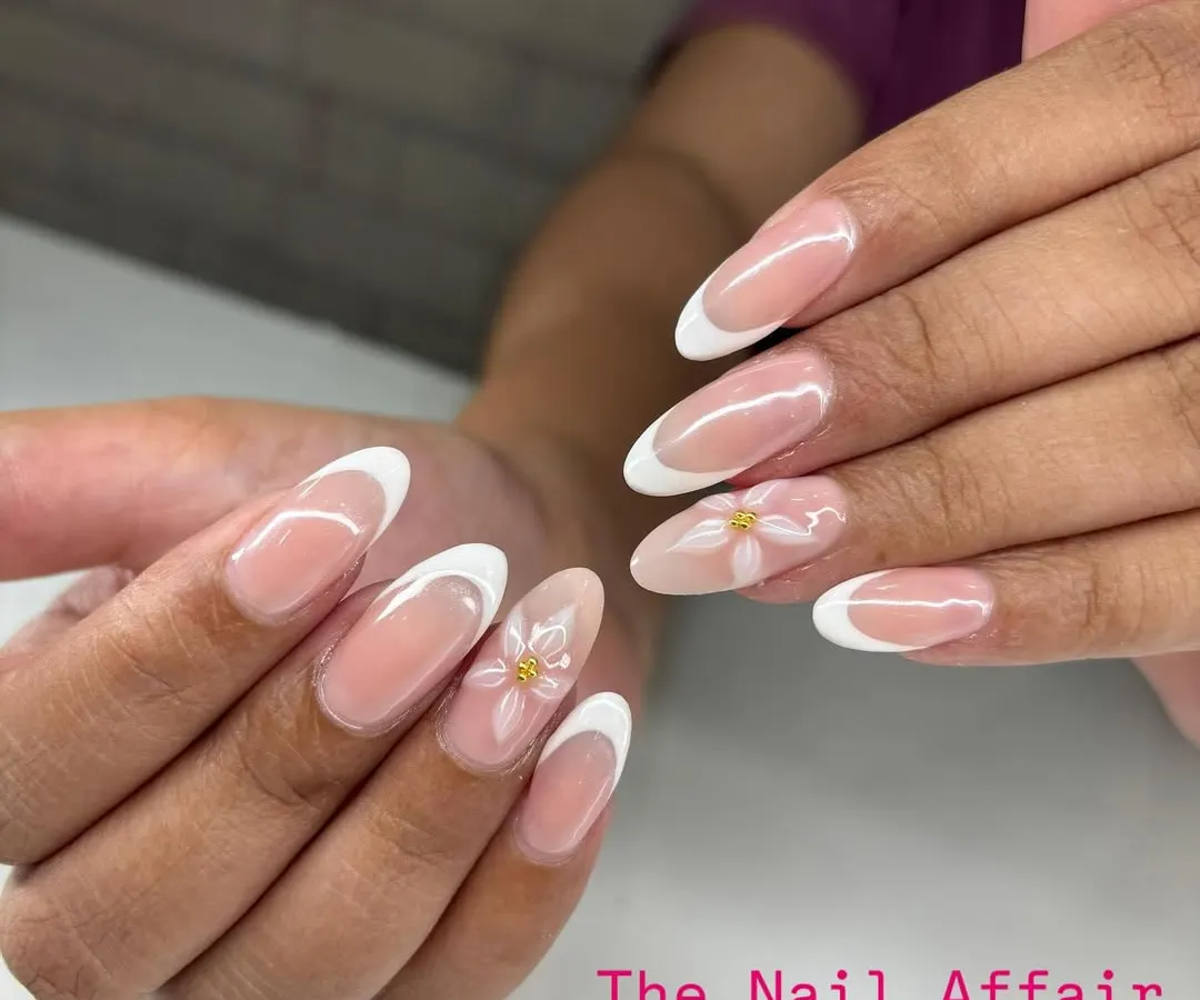 I love putting a creative spin on a classic. This is a timeless French manicure on almond extensions, elevated with delicate, hand-painted white daisies on the accent nails for a touch of spring.